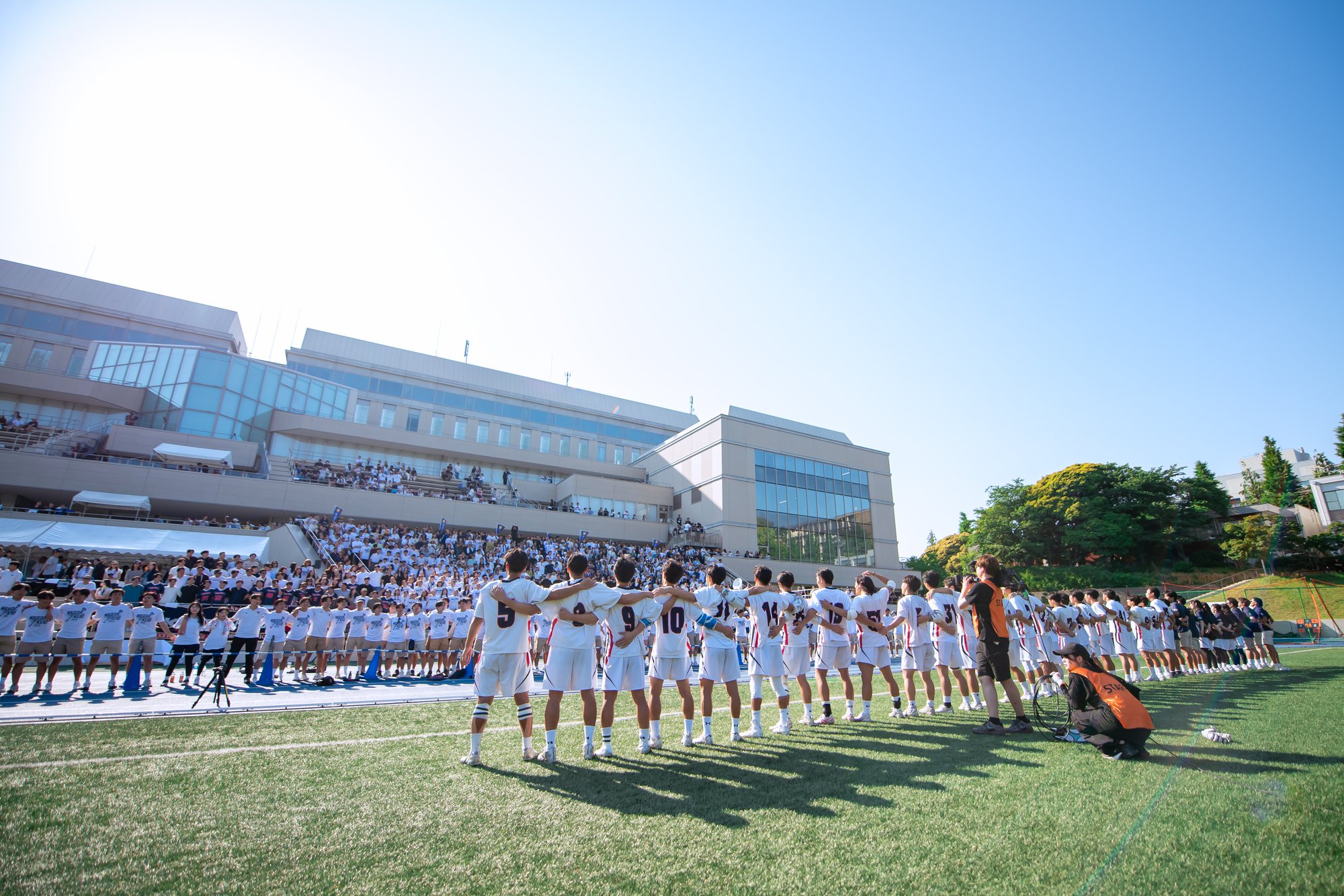 男子部の選手がスタンドの応援に向かって肩を組み並ぶ様子